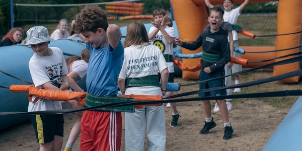 Grupa dzieci śmieje się i bawi duzymi piłkarzykami..jpg