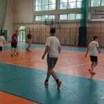 Grupa uczniów gra w piłkę nożną na sali sportowej.jpg