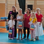 Trzy nauczycielki stoją z trzema uczennicami_ które trzymają nagrody w kolorowych torebkach..jpg