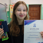 Dziewczynka trzyma dyplom i bilet w rękach