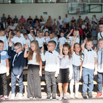 duża grupa uczniów składa przysięgę trzymając dłoń do góry.