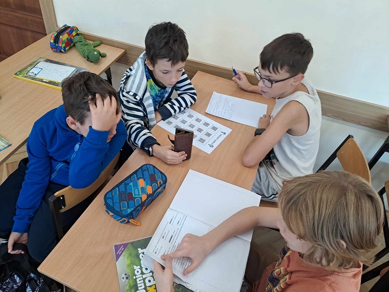 czwórka uczniów siedzących przy ławce.jpg