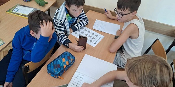 czwórka uczniów siedzących przy ławce.jpg