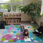 Dwie uczennice czytają książki na kolorowym dywanie..jpg