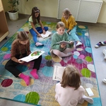 Uczennice czytają książki siedząc na kolorowym dywanie..jpg