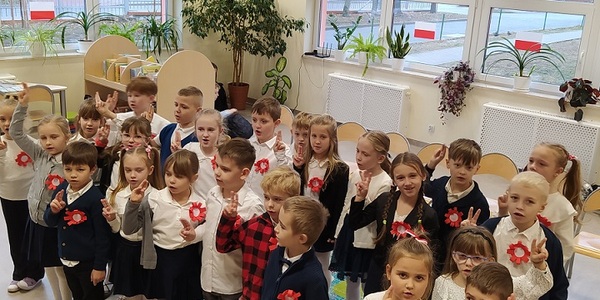 Grupa dzieci ubrana na galowo z przypiętymi kotylionami sklada przysięgę..jpg