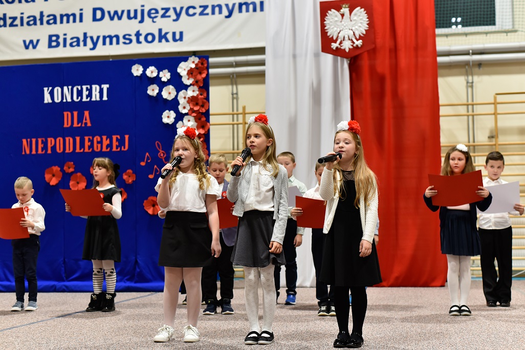 Dzieci ubrane w barwy biało-czerwone śpiewają..jpg