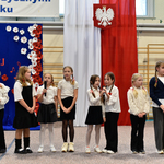 Grupa dzieci ubrana na galowo śpiewa pieśni.