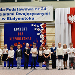 Grupa dzieci ubrana na galowo gra na instrumentach