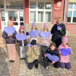 Grupa dzieci trzyma rękach filoletowe serca.jpg