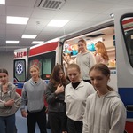 Grupa dziewczyn stoi przed ambulansem.jpg