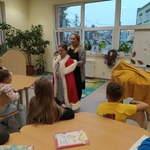 Uczennica przymierza płaszcz króla_ pomaga jej pani ..jpg