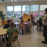 Uczniowie obserwują panie _ które trzymają żółty materiał..jpg