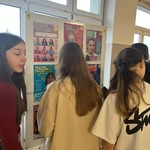 Grupa uczniów stoi przed tablica z plakatami..jpg