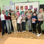 Grupa uczniów z nauczycielką stoi przy tablicy z kolorowymi zdjeciami.jpg