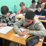 Uczniowie piszą w ławkach listy.jpg