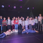 Grupa dzieci razem z nauczycielką stoi na scenie teatru.jpg