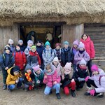 Grupa dzieci stoi przed otwartymi drzwaimi stodoły..jpg