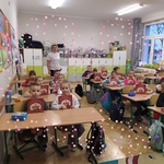 Uczniowie siedzą w ławkach w klasie i trzymają w rękach książki.jpg