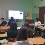 Uczniowie w klasie siedzą naprzeciwko monitoru..jpg