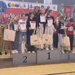 Grupa dziewczyn stoi na podium z dyplomami i upominkami..jpg