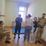 Uczennice współpracują z osobami w mundurach przy udzielaniu pomocy..jpg