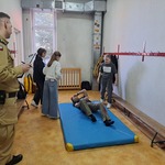 Uczennice zbliżają sie do rannego mężczyzny.jpg