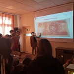 Grupa uczniów obserwuje panią pokazującą na monitorze banknot.jpg